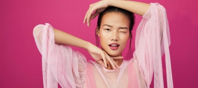 under eye care girl framing her face with pink background